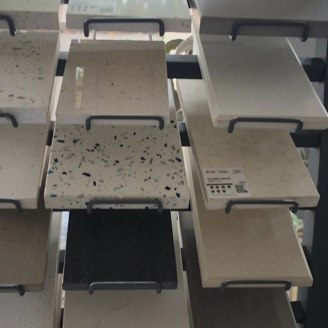 Stone and tile samples displayed on racks in the Dombivli East showroom.